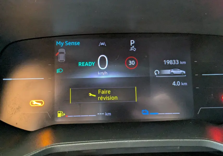Tableau de bord numérique de Renault Clio hybride 2025 affichant 0 km/h, 19833 km, et message "Faire révision".