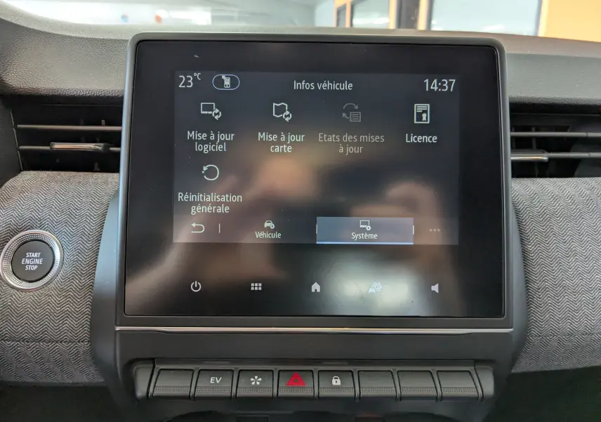 Vue rapprochée de l'écran tactile central et du bouton start/stop sur tableau de bord gris à motif tissu de la Renault Clio hybride 2025.