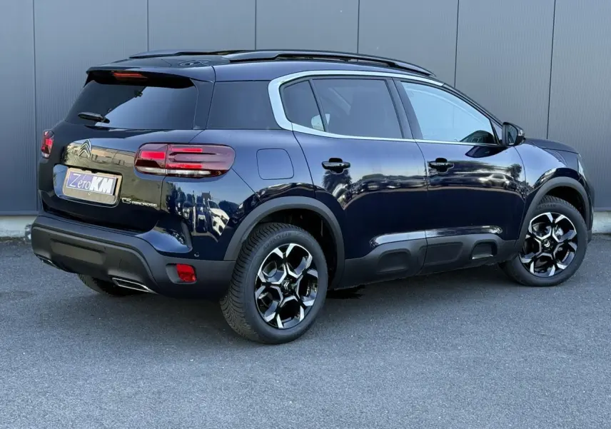 Vue 3/4 arrière droite d'un Citroën C5 Aircross Bleu Eclipse avec jantes alliage bi-ton et toit ouvrant panoramique.