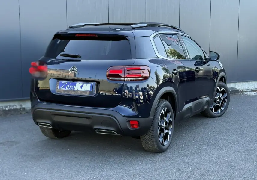 Vue 3/4 arrière droite d'un Citroën C5 Aircross Bleu Eclipse avec jantes alliage bi-ton et hayon électrique.