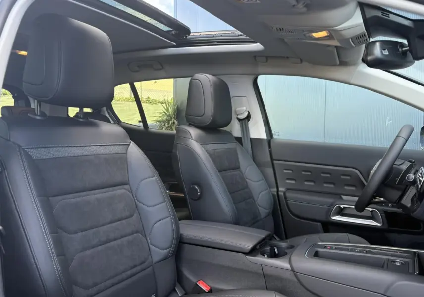 Intérieur avant du Citroën C5 Aircross 2025, sièges Urban Black en Alcantara noir, toit ouvrant panoramique ouvert.