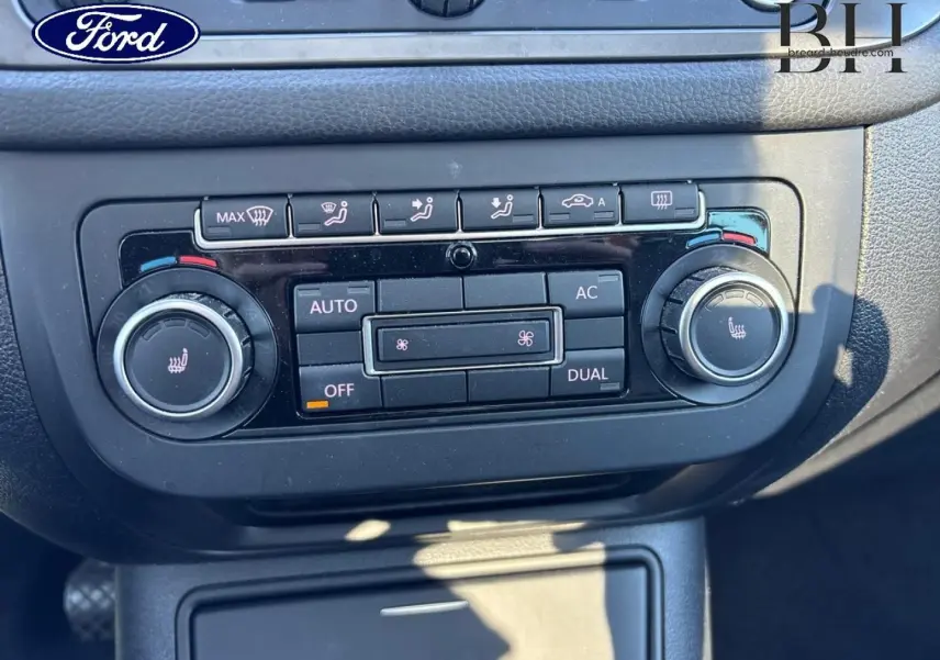 Panneau de commande de climatisation bi-zone noir dans un Volkswagen Tiguan beige, vue rapprochée intérieure.