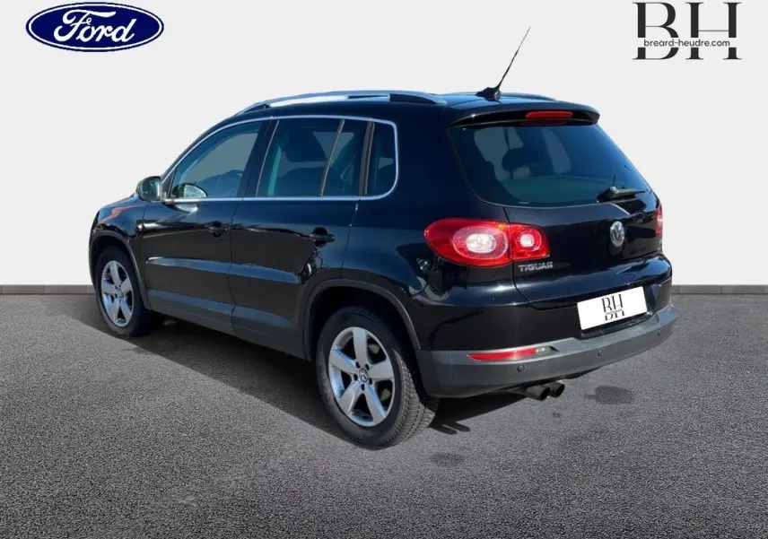 SUV Volkswagen Tiguan noir en 3/4 arrière droit, avec jantes alu et vitres teintées, sur fond neutre.