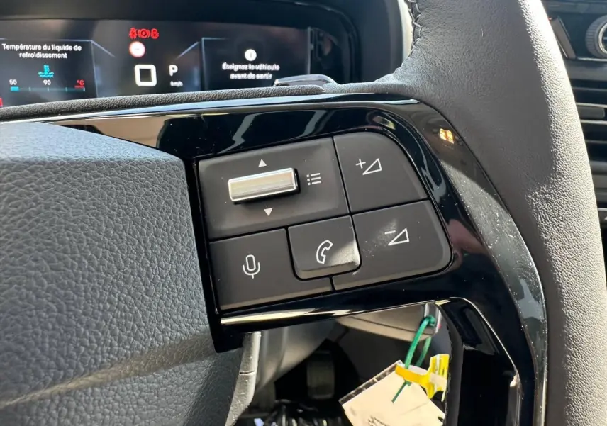Gros plan sur les commandes multifonctions noires du volant cuir du Citroën Berlingo 2026, version BlueHDi.