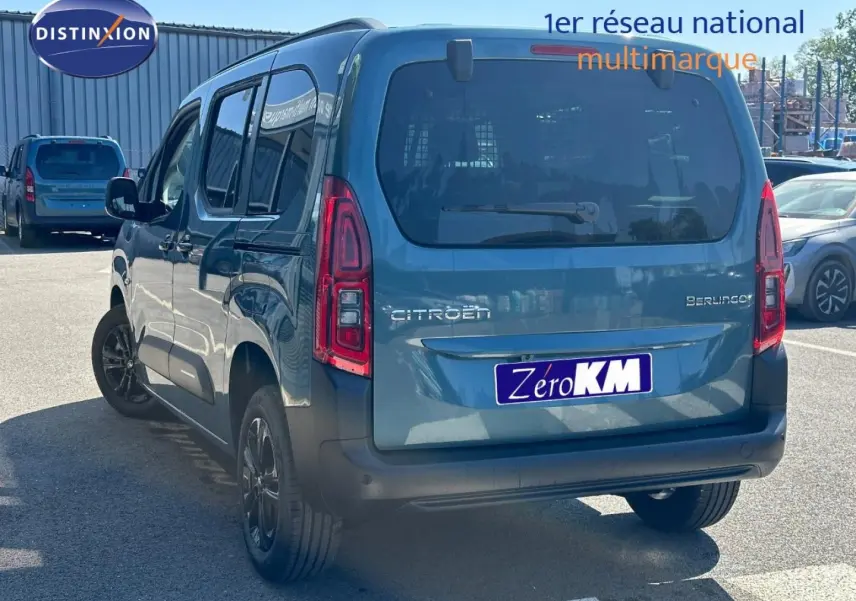 Vue 3/4 arrière droite du Citroën Berlingo 2026 en Kiama Blue avec barres de toit et vitres teintées.