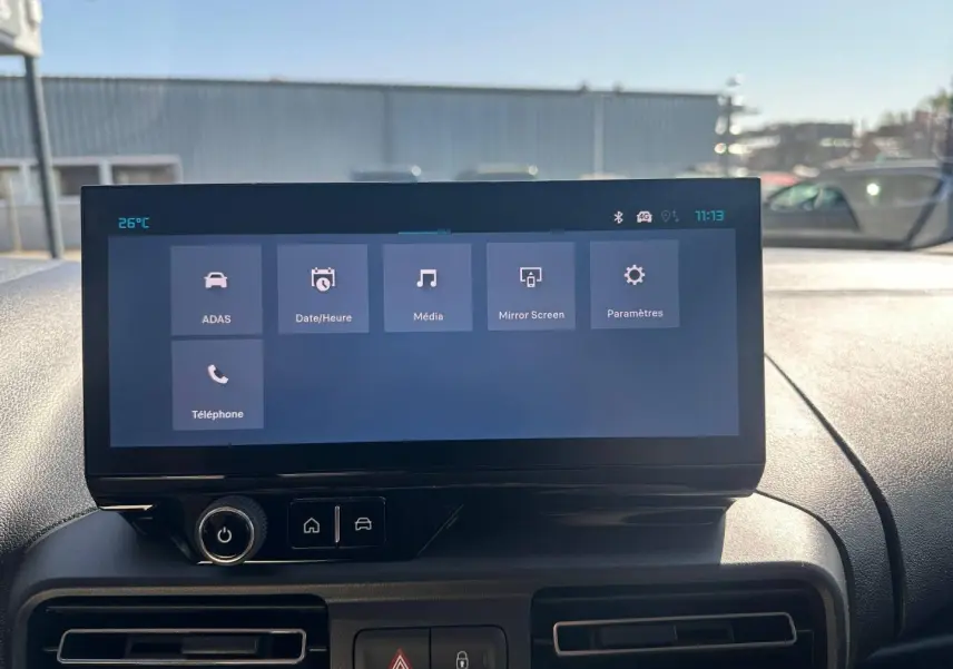 Écran tactile central du tableau de bord du Citroën Berlingo 2026, vue frontale intérieure avec commandes visibles.