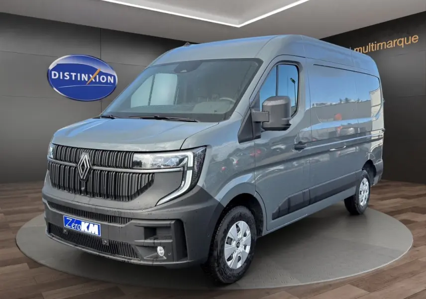 Vue 3/4 avant d’un Renault Master gris métallisé avec calandre noire et feux LED, sur fond intérieur showroom.
