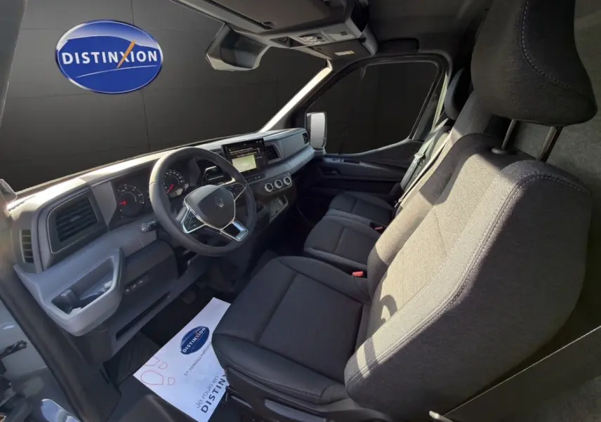 Vue intérieure côté conducteur du Renault Master 2026, sièges gris et tableau de bord avec écran tactile central.