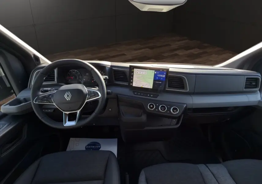 Vue intérieure frontale du tableau de bord gris foncé du Renault Master avec écran tactile central et volant multifonctions.