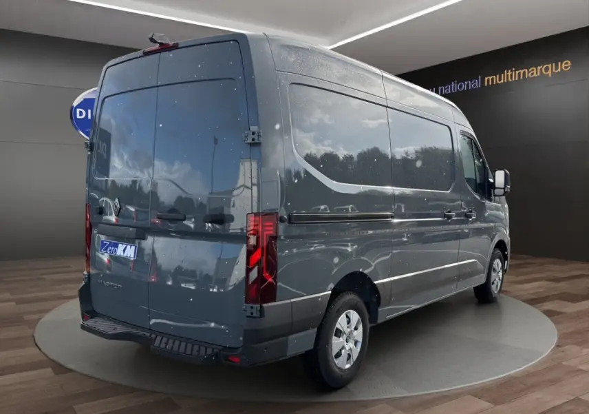 Vue 3/4 arrière droite d’un Renault Master gris foncé avec portes arrière pleines et feux arrière LED, stationné en intérieur.