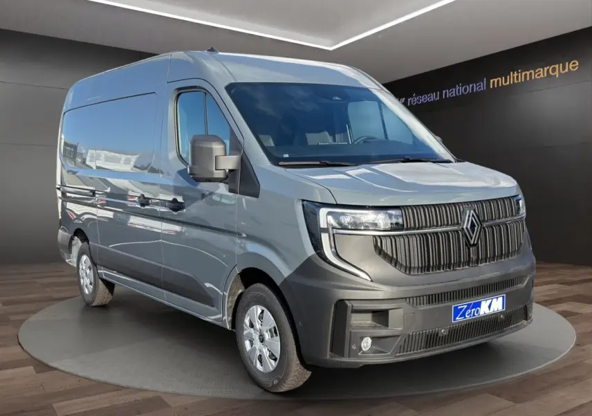 Vue 3/4 avant droite du Renault Master gris avec calandre noire et feux LED, sur plateforme en showroom.