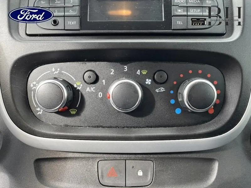 Panneau de commande de climatisation du Renault Trafic Fourgon blanc, avec réglages manuels et boutons fonctionnels visibles.