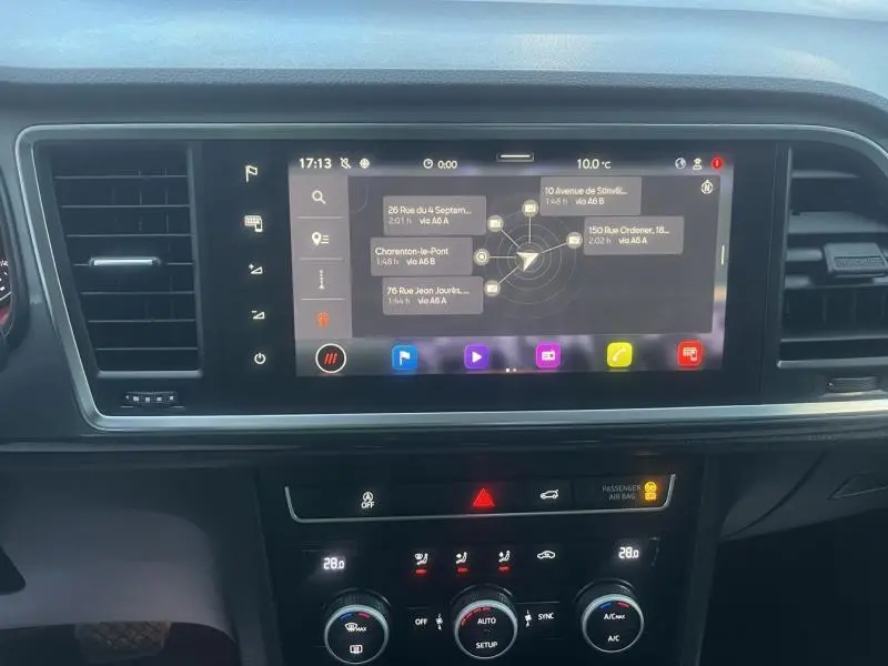 Tableau de bord avec écran tactile multifonction et commandes de climatisation d'un SEAT Ateca noir, vue intérieure frontale.
