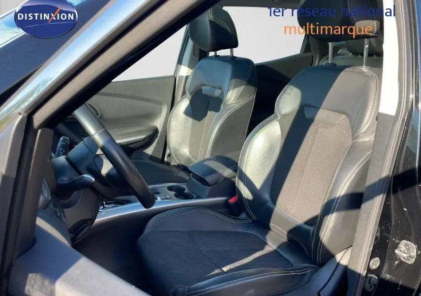 Vue intérieure côté conducteur du Renault Kadjar noir 2018, montrant les sièges en tissu et cuir ainsi que le volant.