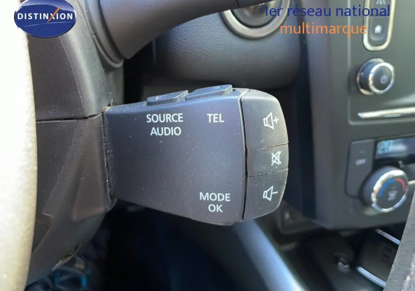 Gros plan sur la commande audio au volant du Renault Kadjar noir, mettant en valeur les boutons source, téléphone et mode.