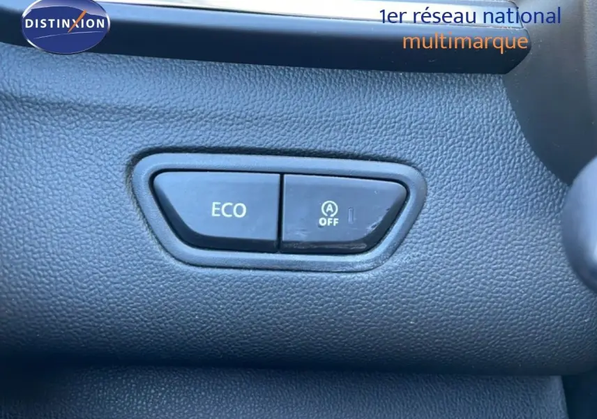 Gros plan sur les boutons ECO et arrêt du système start-stop dans l'habitacle noir du Renault Kadjar 2018.