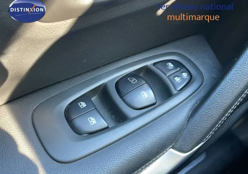 Gros plan sur les commandes des vitres électriques côté conducteur d'un Renault Kadjar noir, intérieur en cuir noir.