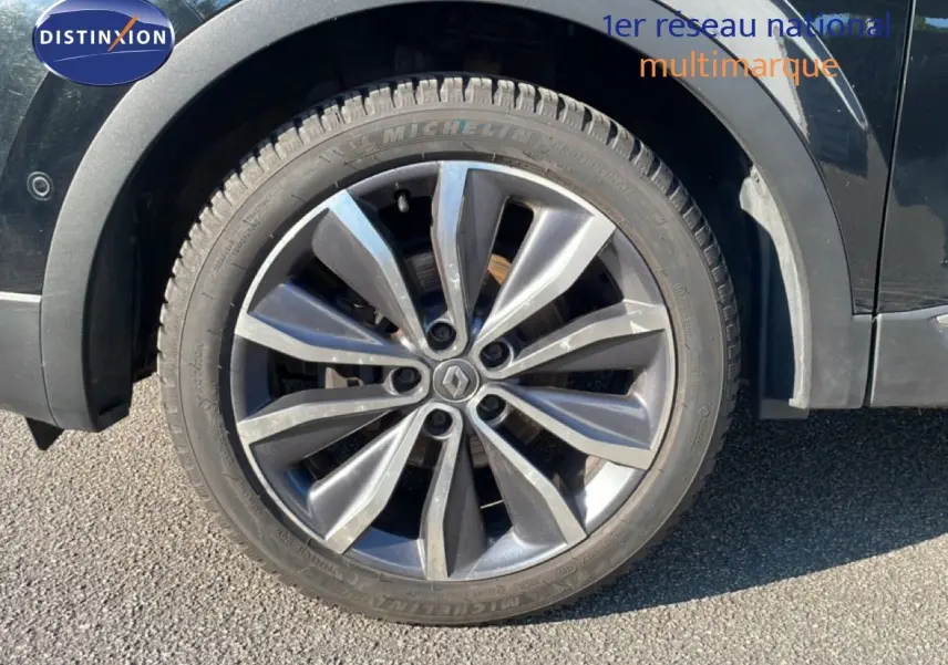 Gros plan sur la roue avant gauche noire d’un Renault Kadjar 2018 avec jante alliage gris foncé.