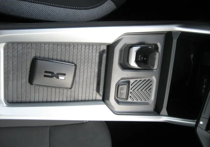 Vue rapprochée de la console centrale noire du Dacia Bigster 1.8 Hybrid 155 ch avec levier de vitesses automatique.