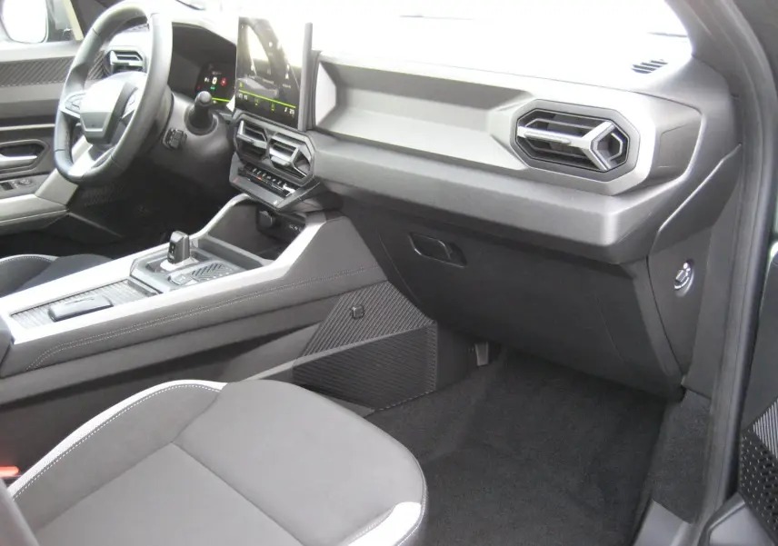 Vue intérieure côté passager du tableau de bord et console centrale du Dacia Bigster 1.8 Hybrid gris schiste, finition Journey.