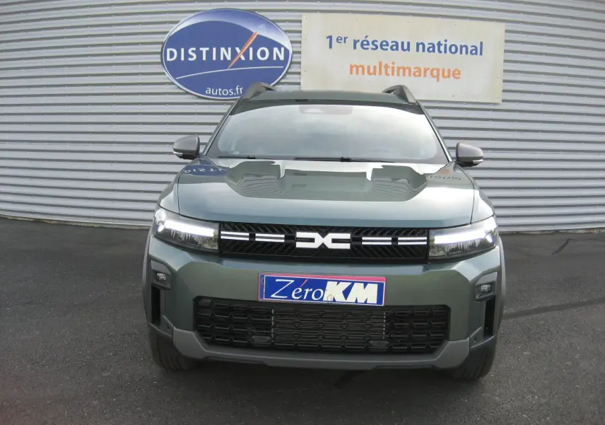 Vue frontale du Dacia Bigster gris schiste 2026 avec calandre noire et phares LED allumés.