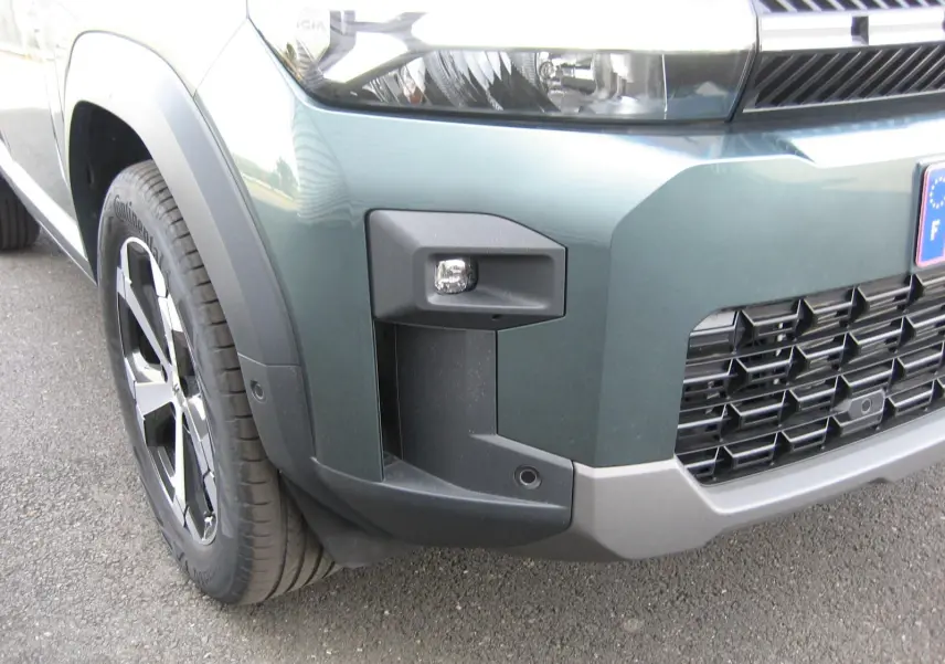 Gros plan sur l’avant droit gris schiste du Dacia Bigster 2026, mettant en valeur le phare et la calandre noire.