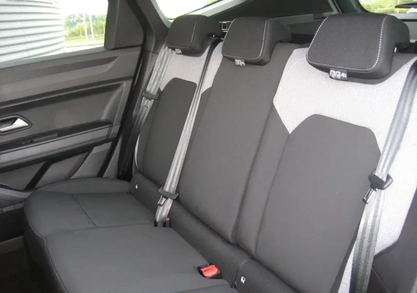 Vue intérieure sur la banquette arrière du Dacia Bigster 2026, sièges bicolores gris clair et noir avec ceintures grises.