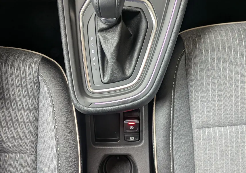 Vue plongeante sur la console centrale noire étoile métal de la Renault Clio 2025, avec levier de vitesse automatique et sièges gris.