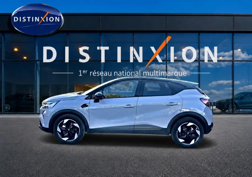 Renault Captur 1.8 e-tech full hybrid 160 techno gris rafale vu de profil côté gauche devant showroom Distinxion.