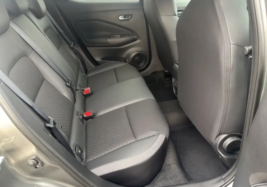 Vue intérieure arrière côté gauche du Nissan Juke 2025 gris squale, montrant les sièges arrière en tissu et cuir.