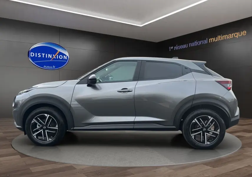 Vue de profil côté gauche du Nissan Juke 1.6 Hybrid 143 N-Connecta gris squale avec jantes alliage et toit noir.