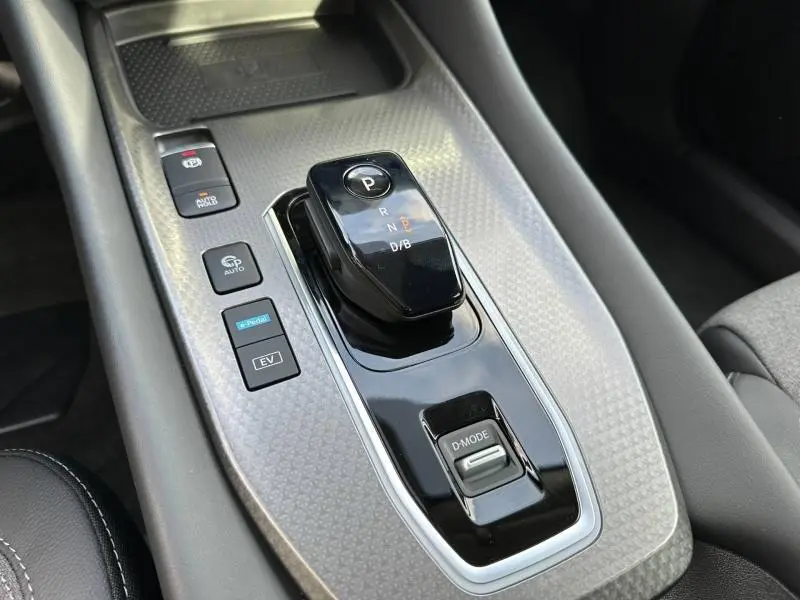 Vue rapprochée de la console centrale du Nissan Qashqai Hybrid e-POWER 2025 avec levier de vitesses automatique et boutons de mode.