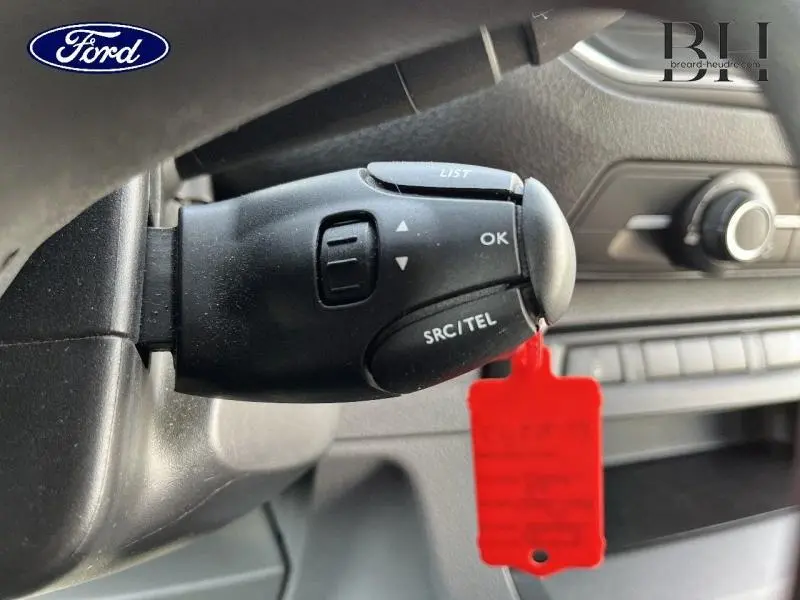 Gros plan sur la commande au volant d’un Peugeot Expert Fourgon blanc, montrant les boutons SRC/TEL et OK.