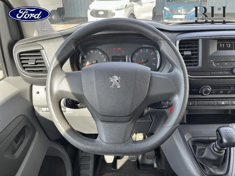 Vue intérieure centrée sur le volant Peugeot d'un Expert Fourgon 2017 avec tableau de bord et levier de vitesses manuel.