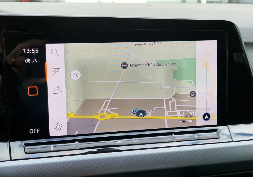 Écran tactile du système de navigation de la Volkswagen Golf 8, affichant une carte avec itinéraire, intérieur moderne.