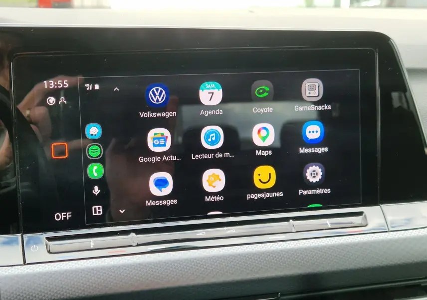 Écran tactile central de la Volkswagen Golf 8 noir intense, affichant plusieurs applications connectées.