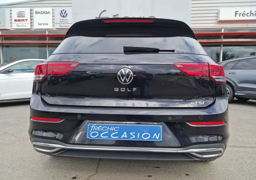 Vue arrière d'une Volkswagen Golf 8 noire intense métal, avec feux LED et badge eTSI bien visibles.