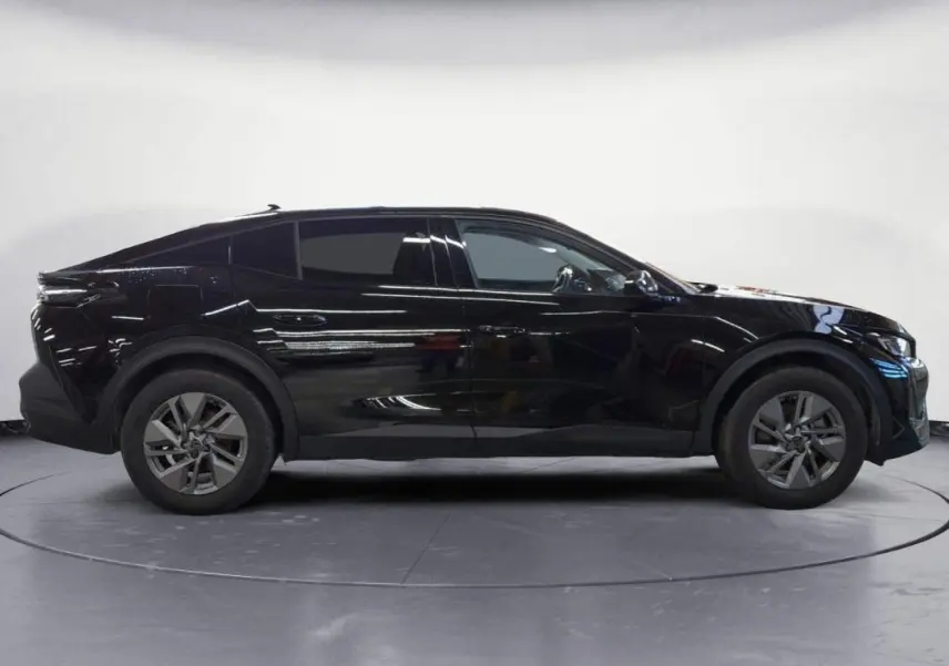 Peugeot 408 PHEV noir vue de profil côté gauche, jantes alliage 17 pouces et lignes dynamiques visibles.