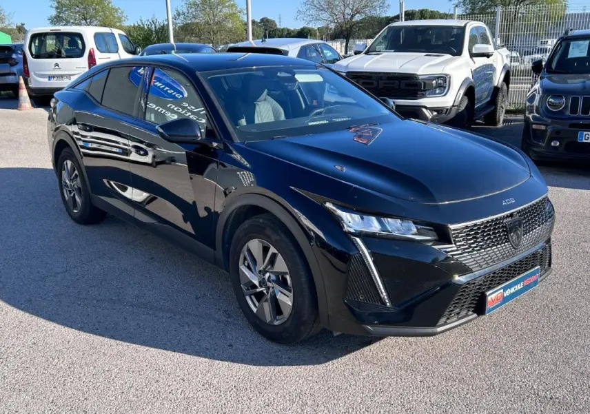 Peugeot 408 PHEV noir vue 3/4 avant droit, avec jantes alliage 17 pouces et calandre distinctive.