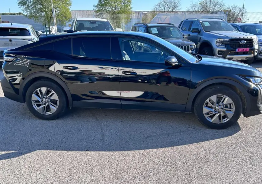 Profil côté gauche de la Peugeot 408 PHEV 180 e-EAT8 Allure noire, avec jantes alliage 17 pouces et vitres teintées.