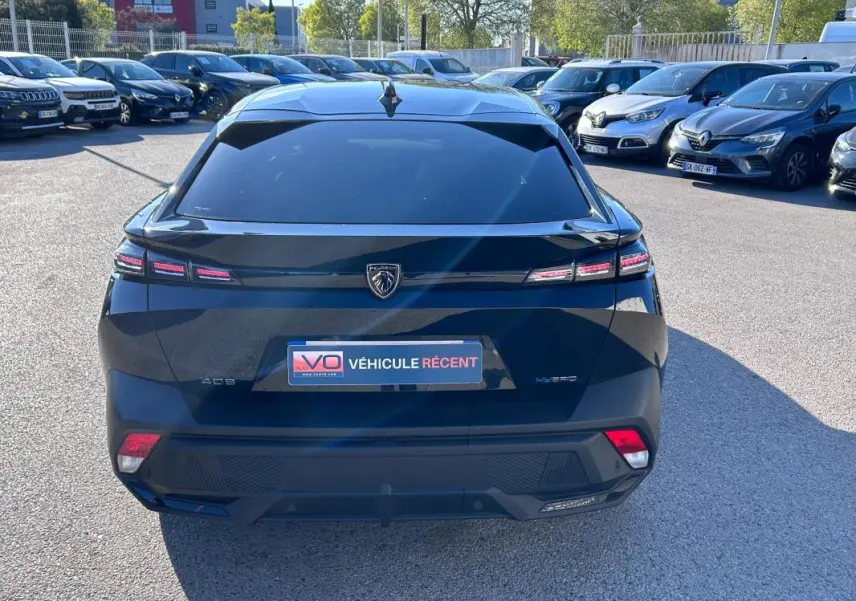 Vue arrière d'une Peugeot 408 PHEV 180 e-EAT8 Allure noire, avec feux LED caractéristiques et lunette arrière teintée.