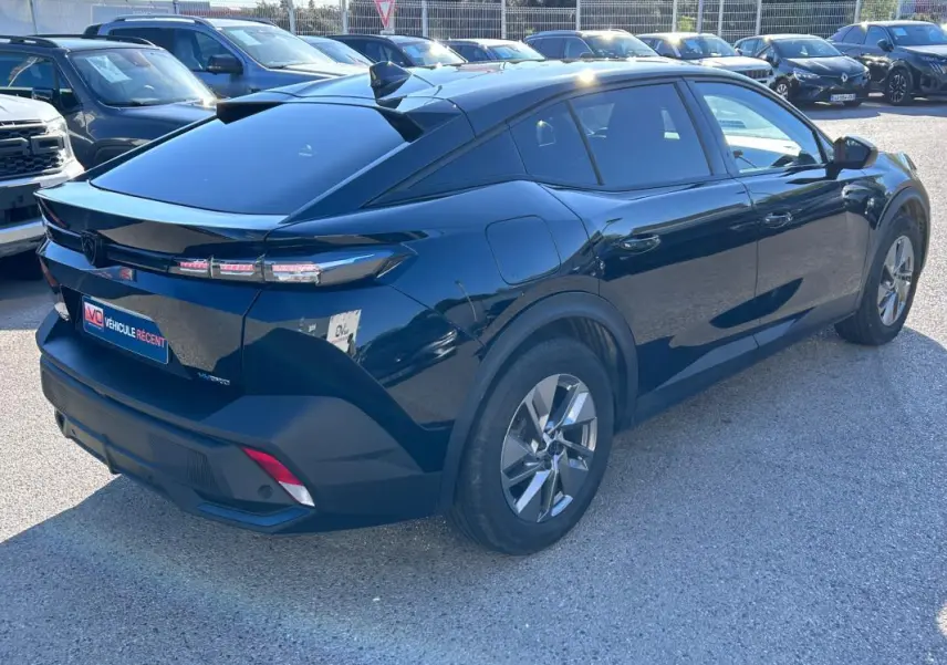 Peugeot 408 PHEV noir en 3/4 arrière droit, avec jantes alliage 17 pouces et toit incliné distinctif.