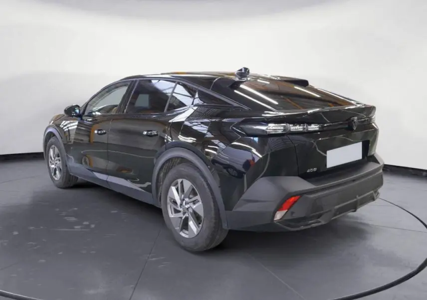 Vue 3/4 arrière droite d'une Peugeot 408 PHEV 180 noire avec jantes alliage 17 pouces et feux arrière LED distinctifs.