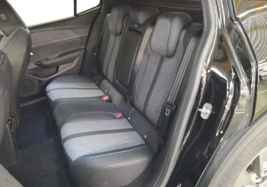 Vue intérieure arrière côté droit des sièges arrière bicolores gris et noir du Peugeot 408 PHEV 180 e-EAT8 Allure noir 2024.