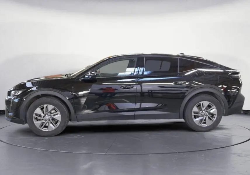 Profil droit d'une Peugeot 408 PHEV 180 e-EAT8 Allure noire de 2024 avec jantes alliage 17 pouces et vitres teintées.