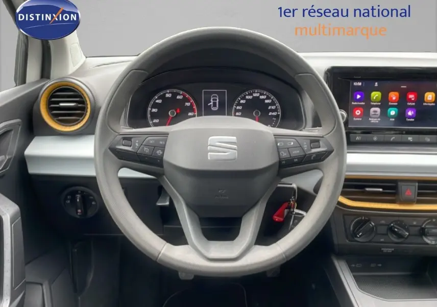 Vue intérieure centrée sur le volant et le tableau de bord de la SEAT Ibiza 2021 avec écran tactile et détails bois clair.