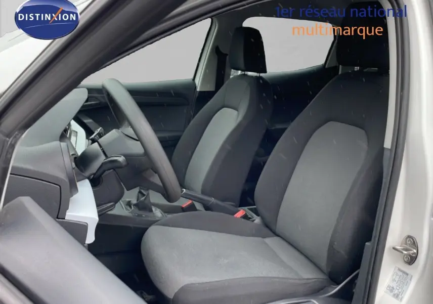 Vue intérieure côté gauche de la SEAT Ibiza blanche Candy 2021, mettant en valeur les sièges tissu noirs et le volant multifonction.