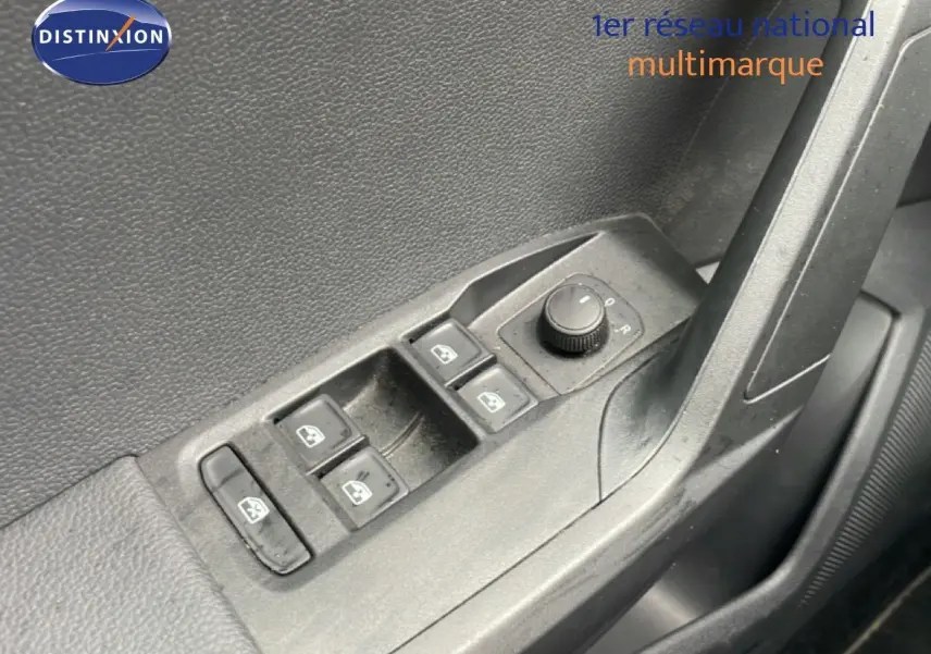 Gros plan sur les commandes de lève-vitres et réglage des rétroviseurs côté conducteur d'une SEAT Ibiza blanc candy.