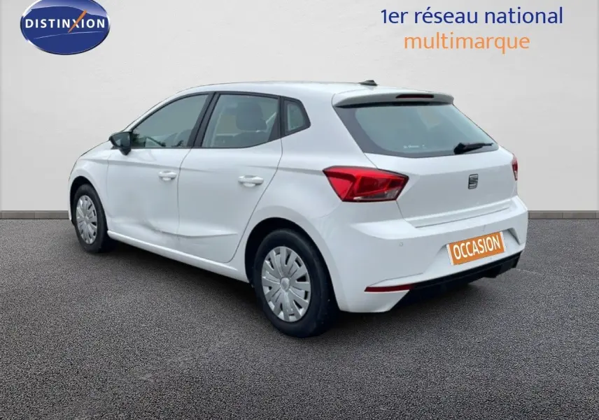 Vue 3/4 arrière droite d'une SEAT Ibiza blanche Candy avec jantes acier et feux arrière LED, sur fond neutre.