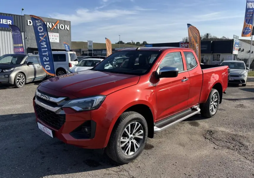 Vue 3/4 avant gauche d’un pick-up Isuzu D-MAX orange avec jantes aluminium et marchepieds métalliques.